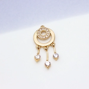 Macro view of gold-plated celestial pendant with cubic zirconia circles and triple tassels