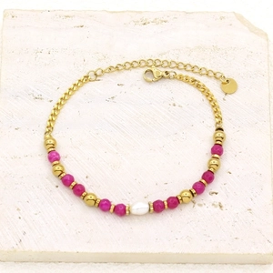 Detailed macro shot of gold-plated bracelet with freshwater pearl and pink stone beads