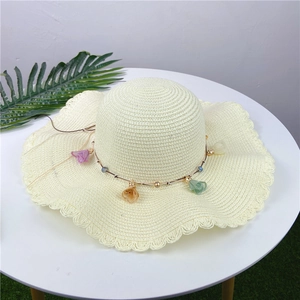 Creamy white straw sun hat with wavy brim and colorful crystal charm chain decoration