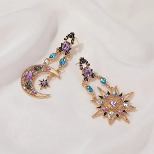 Vintage baroque sun and moon earrings with colorful rhinestones on white silk background