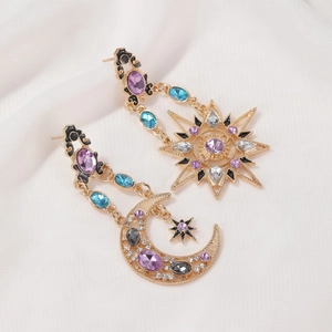 Detailed close-up of celestial sun and moon earrings with colorful crystal inlay