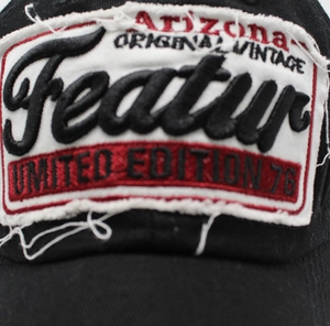 Close-up of vintage distressed embroidery patch on a black baseball cap detail