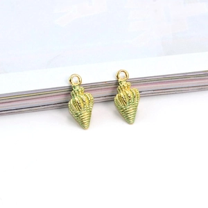 Macro detail of gold-plated seashell charms with light green oil-drip enamel finish