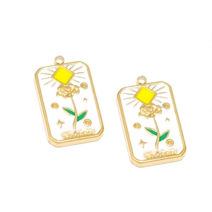 Detail of gold-plated rectangular tarot-style rose pendants with embossed Lovers engraving
