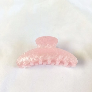 Top view of large pink marble texture hair claw clip made of polished resin material