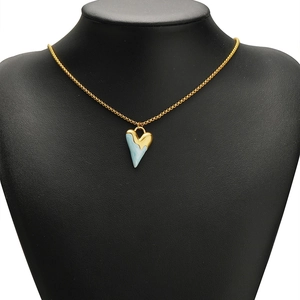 Golden heart pendant necklace with light blue marble texture on a black neck model