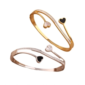 Elegant heart-shaped open bangle in gold and silver finish with inlaid rhinestones