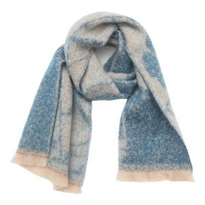 Detail showing the thick knitted texture and blue floral pattern of the tassel scarf