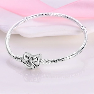Silver snake chain bracelet featuring a sparkling crystal bow clasp for DIY charms