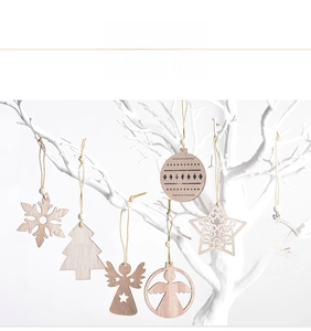Detail of wooden Christmas ornaments with snowflake and star patterns on white branches