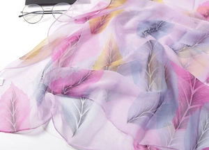 Macro view of silky chiffon fabric with colorful feather patterns and soft texture