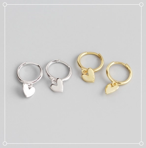 Close-up of gold and silver S925 sterling silver heart charm hoop earrings
