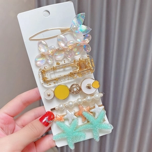 Detailed close-up of 8-piece pearl hair clip set with mermaid tail and floral designs