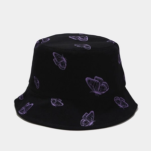 Détail du chapeau bob en coton noir avec des motifs de papillons violets brodés sur le tissu