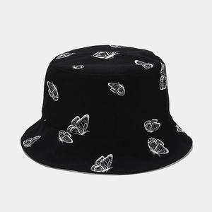 Détail d'un chapeau bob en coton noir orné de motifs imprimés de papillons blancs