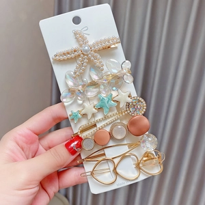 Detailed close-up of 8-piece pearl and resin hair clip set with starfish and heart motifs