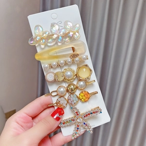 Detailed view of an 8-piece pearl and rhinestone hair clip set on a white card