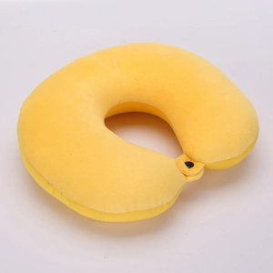 Detail of soft yellow plush U-shaped neck pillow with black snap button fastener