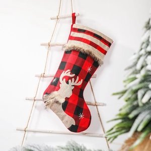 Christmas stocking with red and black plaid patterns, plush trim, and deer embroidery hanging