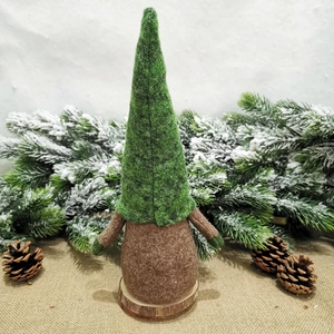 Dettaglio di uno gnomo natalizio con cappello in feltro verde e base in legno naturale