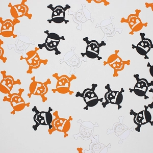Halloween skull and crossbones confetti in black, orange and white for party decor