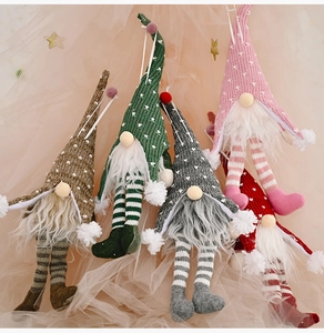 Detail of colorful knitted Christmas gnomes with striped legs and glowing hats
