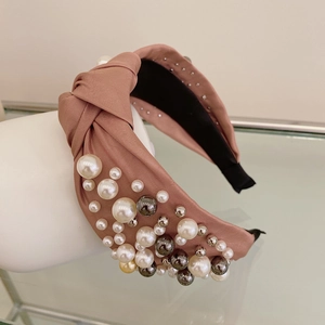 Detail of dusty pink satin headband with hand-sewn pearls and twisted knot design