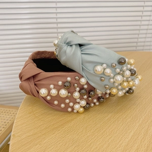 Detailed view of mint green and dusty pink fabric headbands with elegant white faux pearls