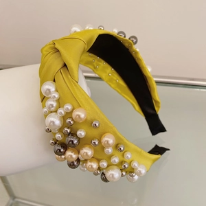 Detailed shot of yellow fabric headband with mixed white and champagne pearls