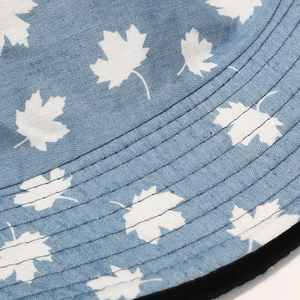 Detail of light blue sun hat with white maple leaf print and reinforced stitched brim