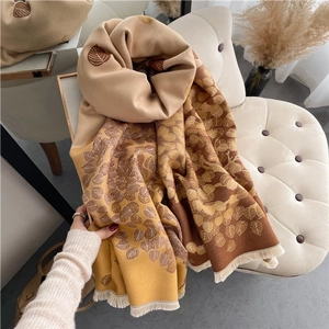 Close-up of leaf pattern jacquard scarf with elegant beige and brown fringe details