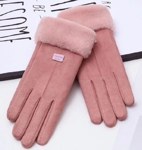 Close-up of pink faux suede winter gloves with fluffy fur cuffs and leather fashion label