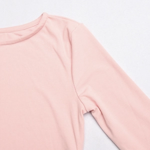 Detailed close-up of pink ribbed knit texture and stitching on the crew neck shoulder area