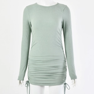 Detail view of sage green long sleeve mini dress featuring side drawstring and ruched texture