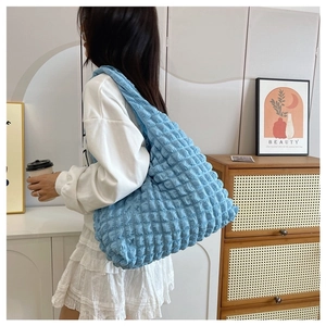 Close-up of blue pleated puff shoulder bag showing texture and 3D floral pattern