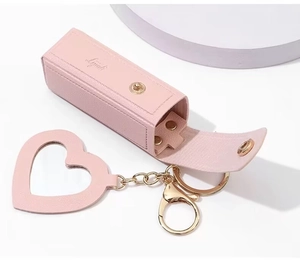 Pink leather lipstick pouch with heart mirror charm and gold keychain detail