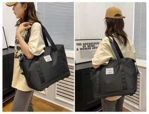 Front and back view of a large black waterproof nylon travel bag with expansion layer