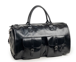 Detail view of the black leather travel bag with large buckled pockets and metal hardware