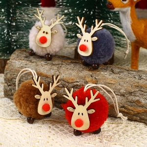 Detail of four reindeer plush ornaments with wooden heads on a festive lace background