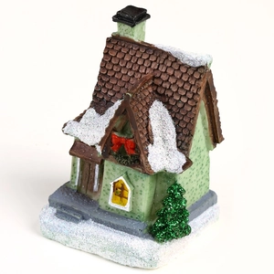 Light green glowing resin Christmas village house with snow roof and festive tree ornament