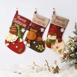 Three Christmas stockings with Santa, reindeer, and snowman hanging on a wall