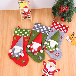 Three large Christmas stockings with gnome doll designs on a rustic wooden background