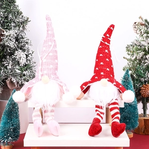 Charming pink and red Christmas gnomes with knit hats and glowing legs on a stool