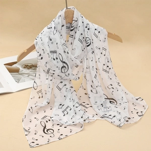 Detail of white chiffon scarf with black music note print hanging on a wooden hanger