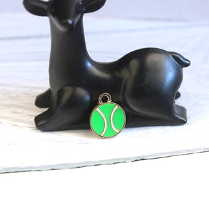 Detailed close-up of a green tennis ball charm with golden alloy metal base for DIY jewelry