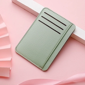 Detail view of ultra-thin PU leather card holder in sage green with lychee texture