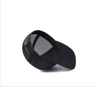 Detail view of black mesh truck hat showing breathable fabric and plastic snapback closure