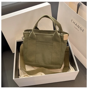 Detail of green canvas tote bag in white gift box with detachable shoulder strap