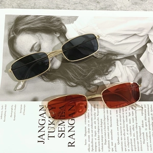 Close-up of black and orange rectangular metal sunglasses on a fashion magazine