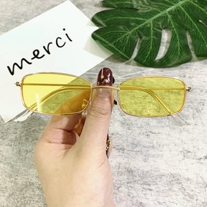 Detail of yellow tint lenses with gold metal rectangular frame sunglasses for unisex